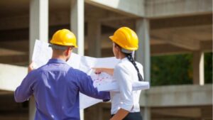 man and woman working side by side at a construction site reading drawings